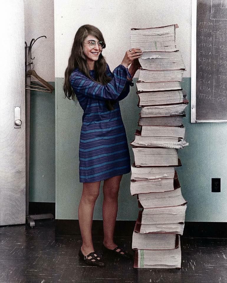 Margaret Hamilton, lead software engineer for NASA's Apollo program, standing beside handwritten code